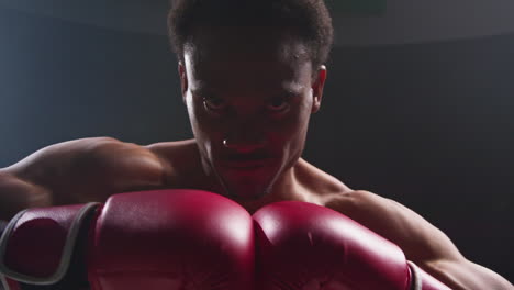 Retrato-De-Un-Boxeador-Con-Guantes-En-El-Ring-Haciendo-Un-Gesto-Agresivo-Antes-Del-Inicio-Del-Combate-De-Boxeo-Calentando.