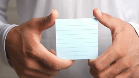 person holding a light blue sticky note