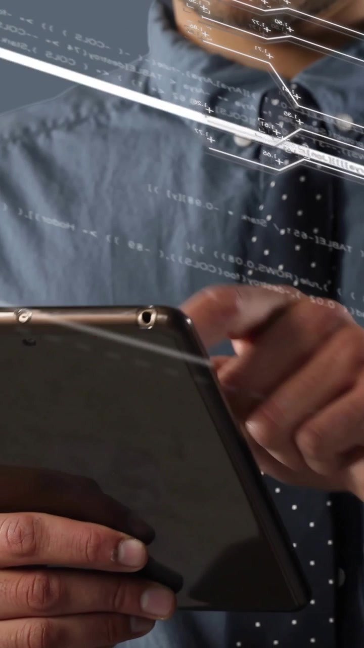 Vertical video: Man tapping tablet, using HUD and analyzing data with circuit lines crossing torso