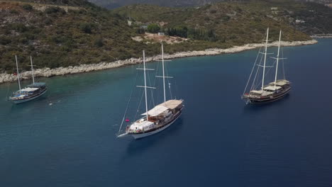 rising aerial orbits tourism ships anchored in clear mediterranean sea