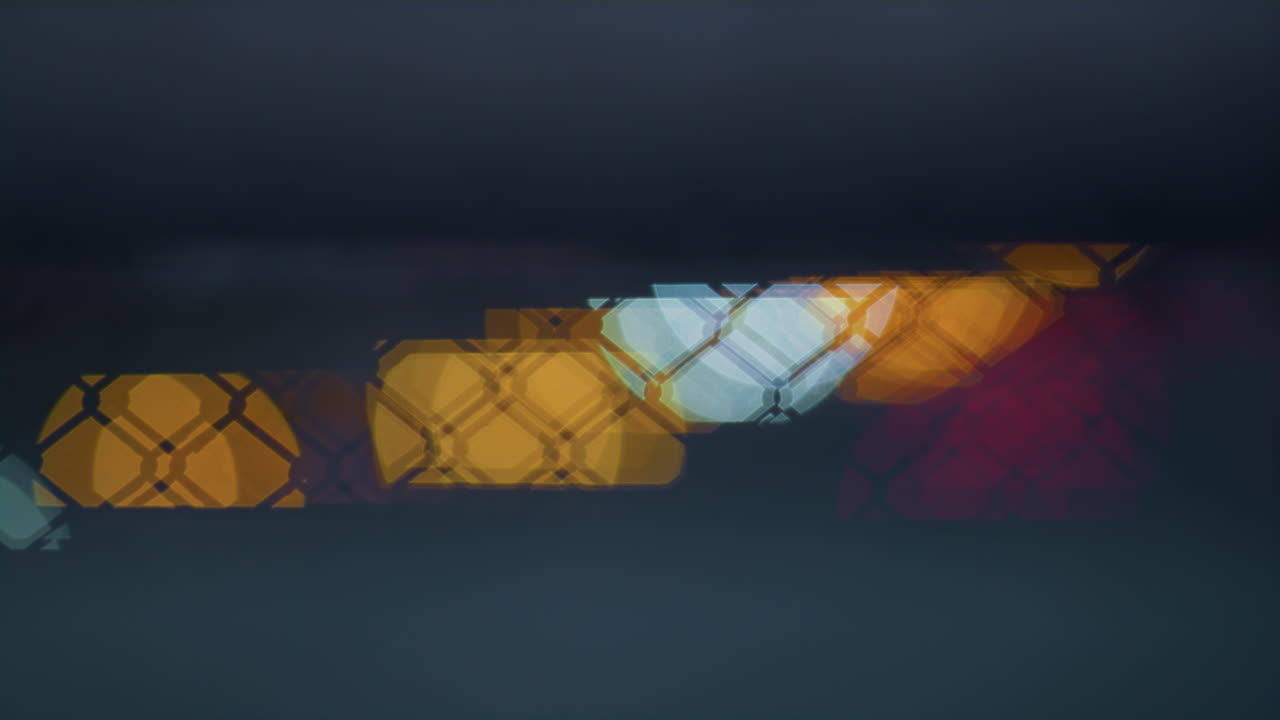 luces borrosas de la ciudad parpadeando a través de una red metálica. iluminación abstracta.