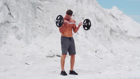exercise for biceps in nature. a man in shorts comes up and raises the bar