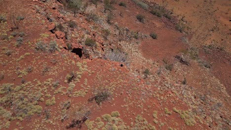 Man-sitting-on-edge-of-rocky-mountain-contemplating-panorama-in-Western-Australia-desert