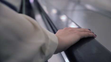 woman using an escalator handrail