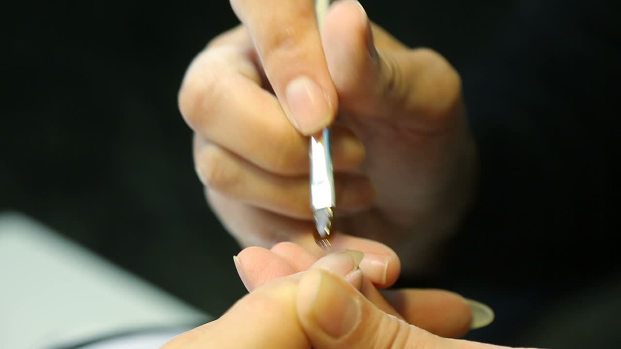 Manicurist treating client at beauty salon