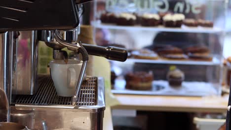 crop barista preparing drink in coffee machine