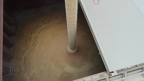 industrial grain loading process as ship is filled with bulk agricultural cargo