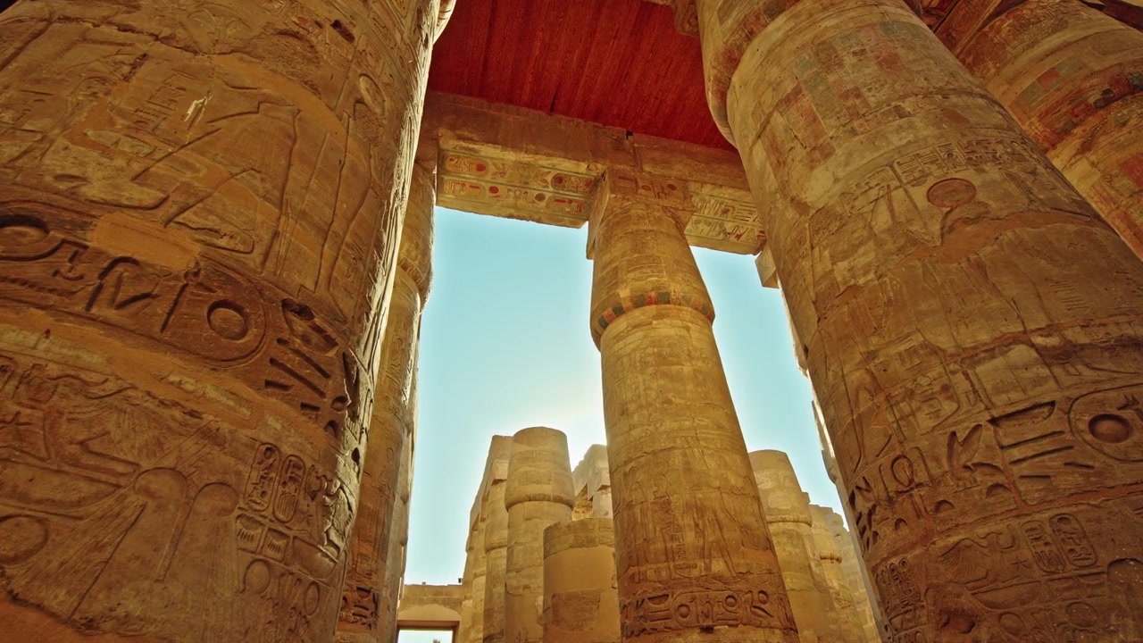 Bagliore solare tra colonne geroglifiche e soffitto dipinto al Tempio di Karnak