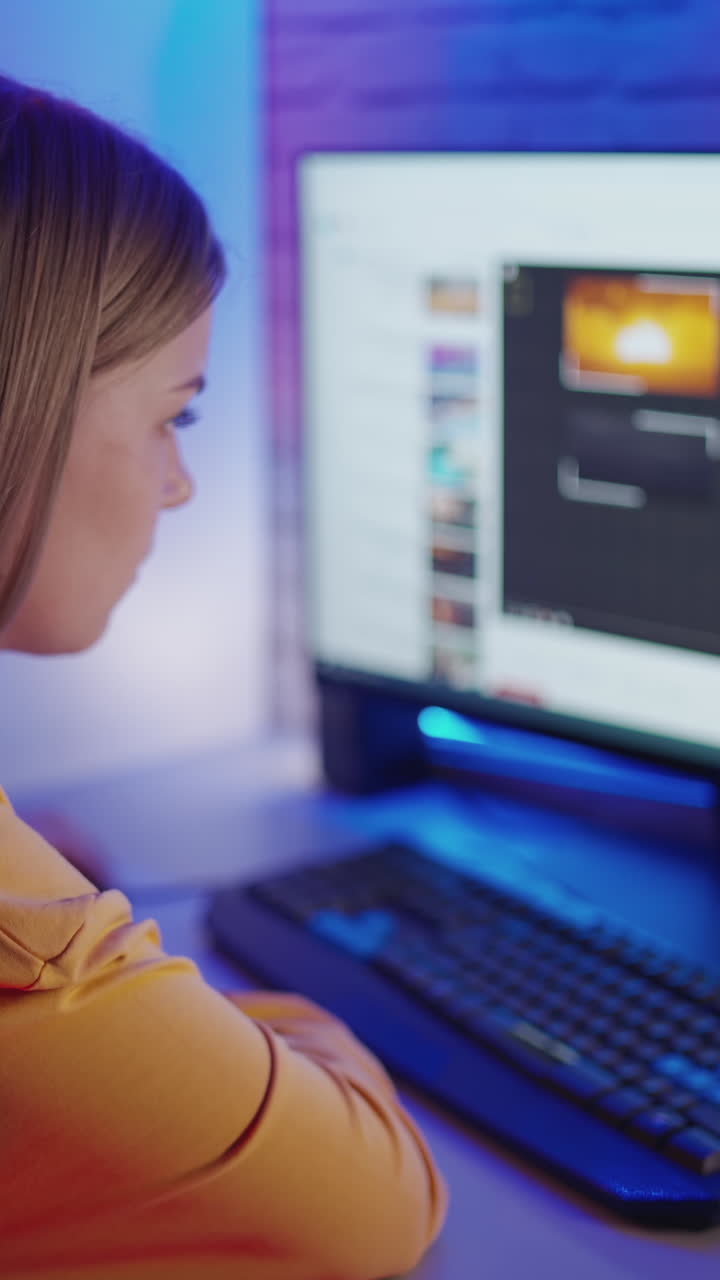 Teenager watching video at home. Young woman looking at computer at home