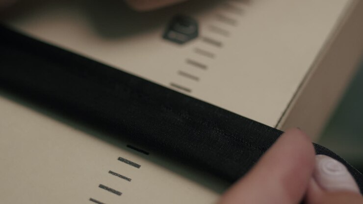 The designer is measuring the fabric