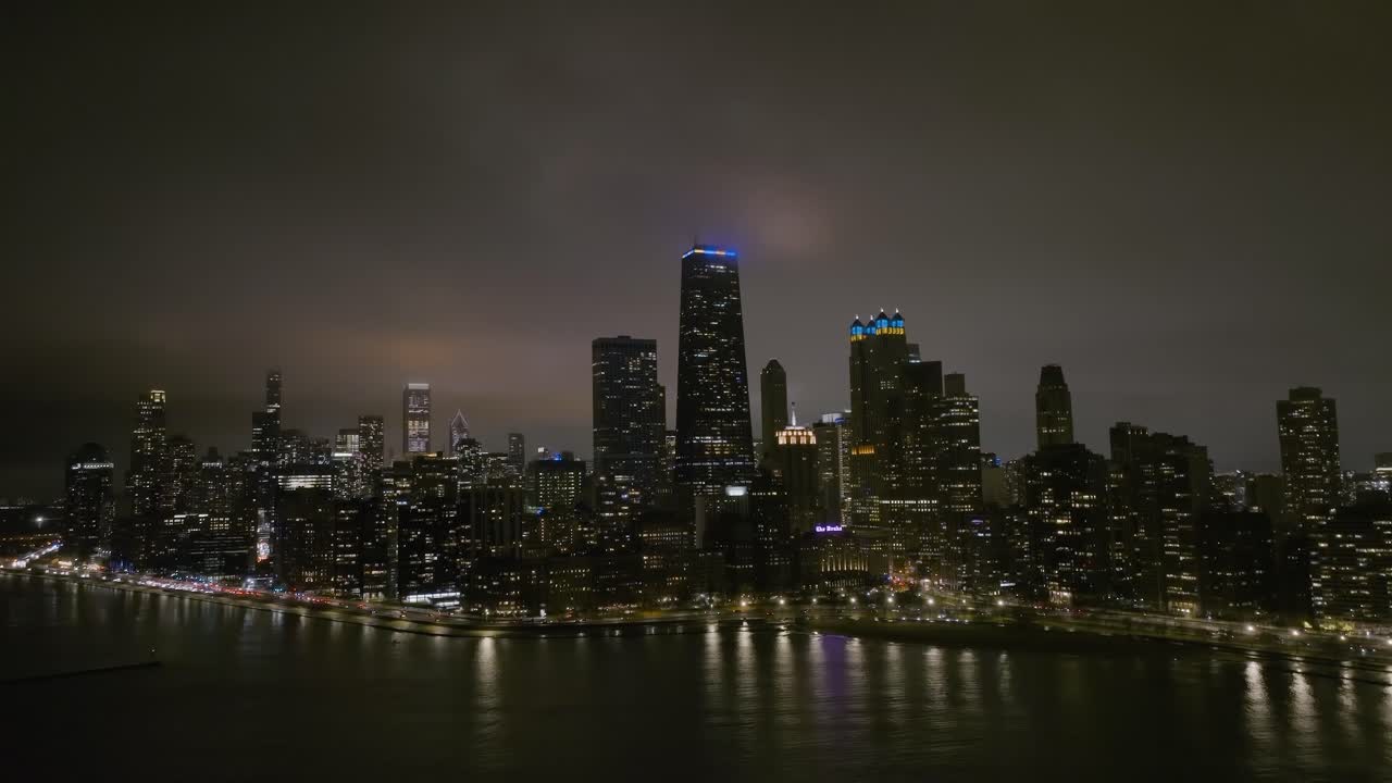 Aerial view orbiting around the Streeterville skyline, foggy night in Chicago, USA