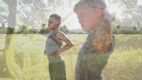 Animation-of-sunlight-and-trees-over-diverse-schoolboys-exercising-in-outdoor-fitness-class