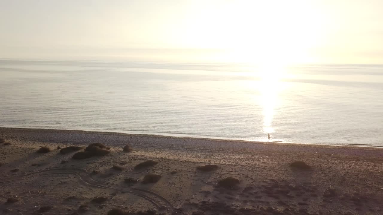 Man running on the beach. Orbital shot with drone
