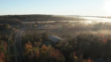 High-Aerial-Pan-Drone-Footage-overlooking-barn-and-treeline-at-MDI,-Maine,-USA-on-a-foggy-day