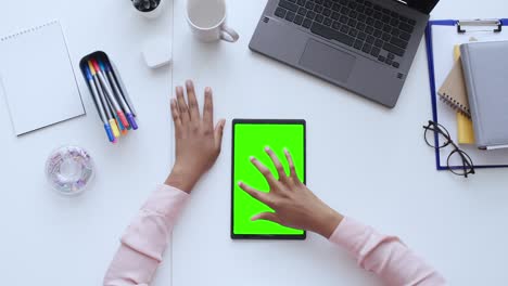 top view of businesswoman scrolling tablet with green screen, online application