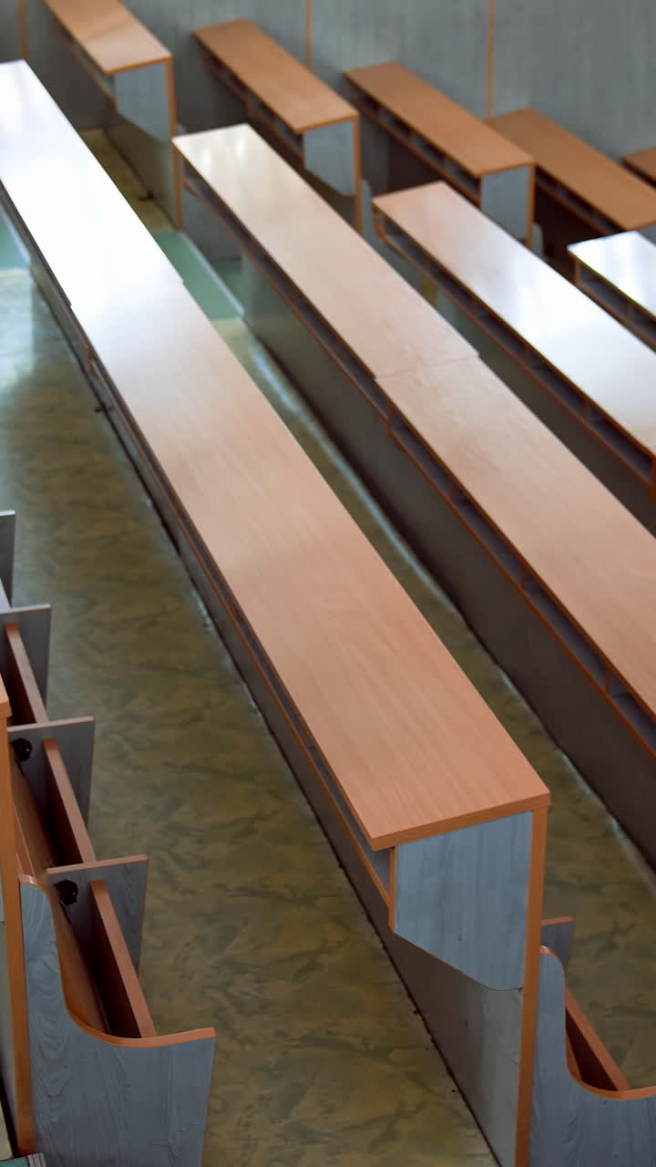 Empty classroom in university. Shot of university classroom with rows of chairs and desks. Vertical video