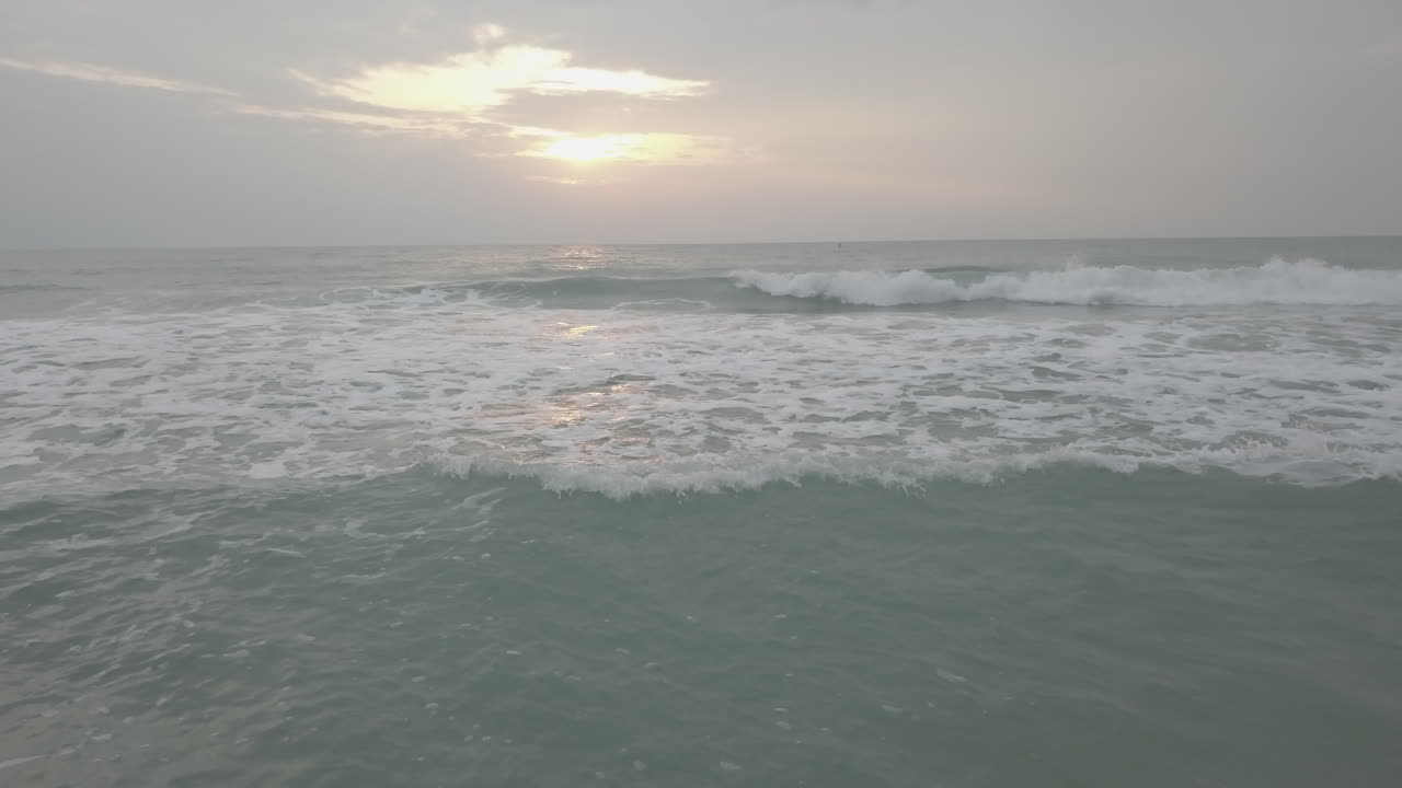 바다의 파도 위에서 해가 뜨는 것