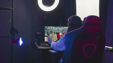 back view frustrated woman wearing headphones leaning back in gaming chair after losing intense match, hand on mouse, neon lights reflecting modern studio vibe