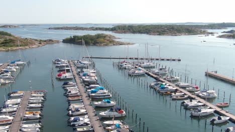 Luxury-boats-docked-at-majestic-pier-in-Sweden,-aerial-orbit-view