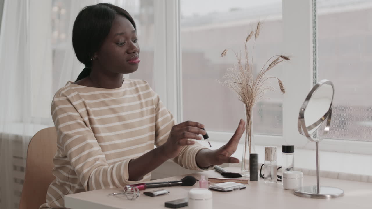 Young African-American Woman Applying Nail Polish