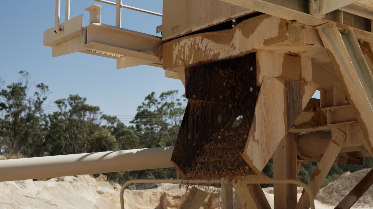 Sabbia e ghiaia in fase di lavorazione attraverso un sistema di vagliatura industriale in una cava