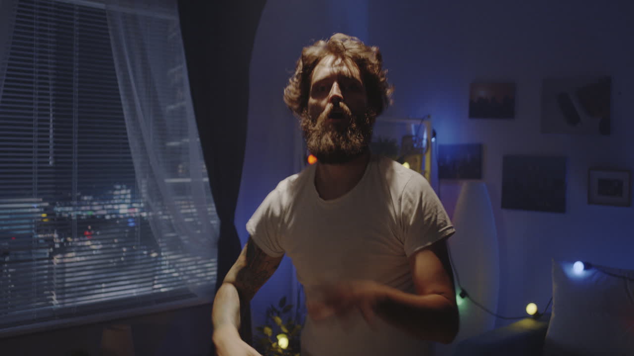 Man dancing and stretching in his bedroom at night