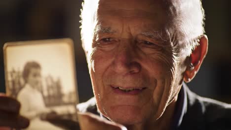 an elderly man reminiscing while holding a vintage photograph, capturing unforgettable memories and emotions through time in a touching moment of reflection