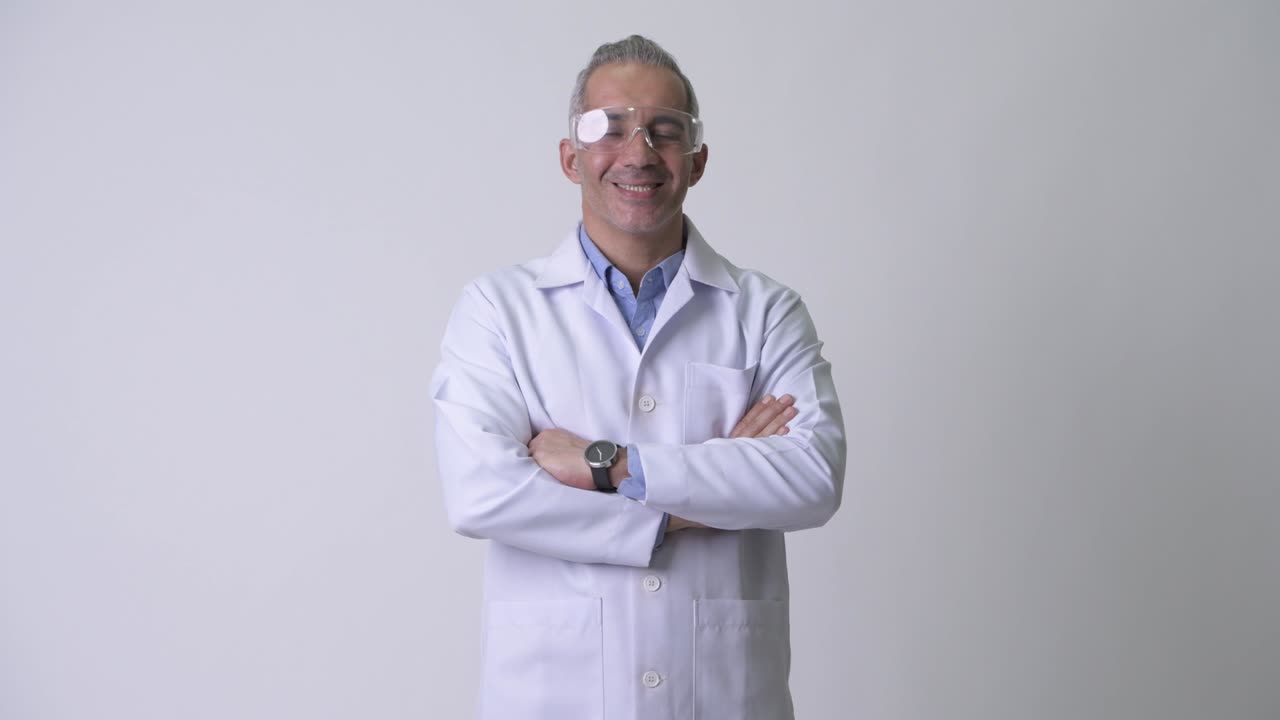 Happy mature Persian man doctor as scientist with arms crossed