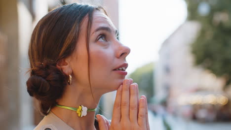 retrato de una mujer orando con los ojos cerrados a dios pidiendo bendición ayuda perdón al aire libre