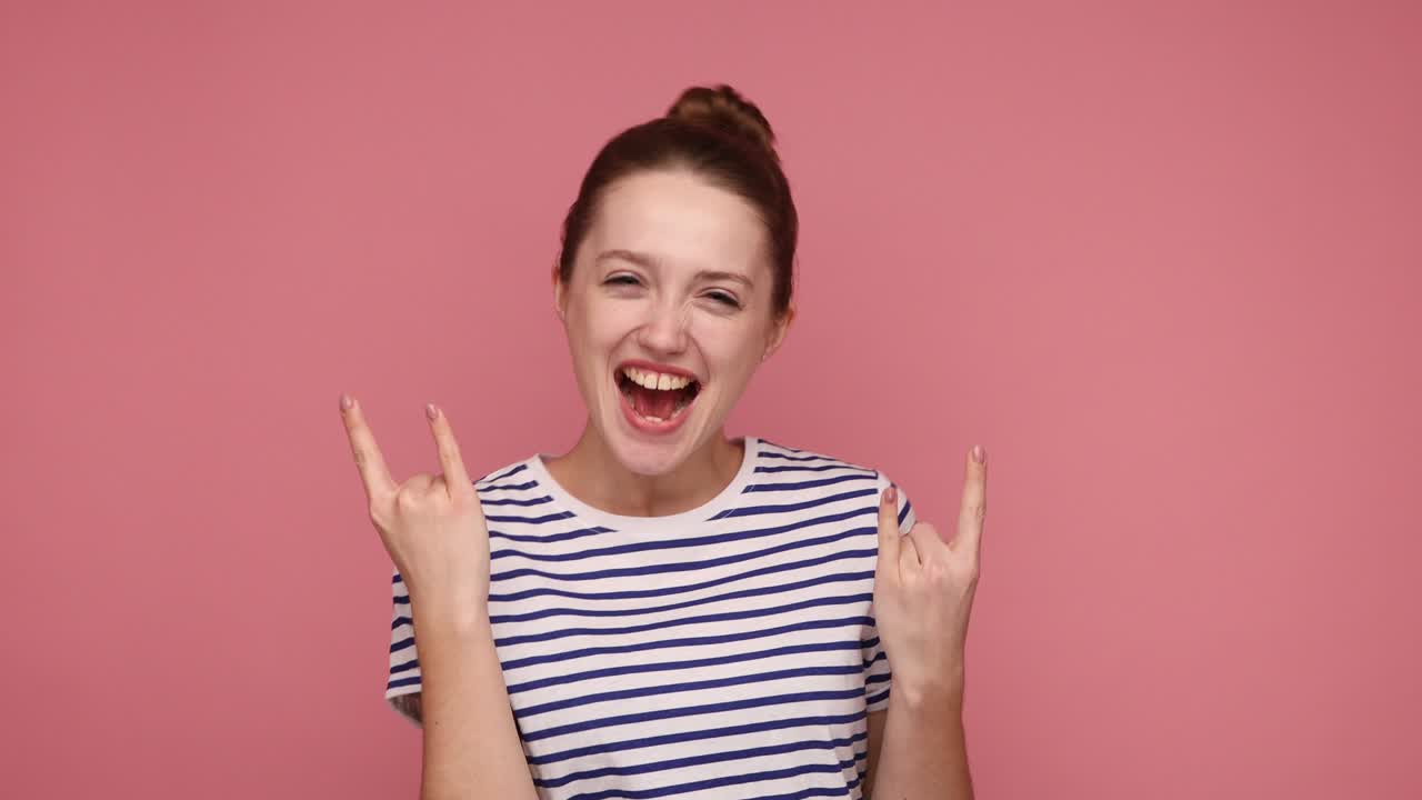 락 앤 롤의 손짓을 보여주고, 헤비 메탈, 록 음악에 소리치고 몸짓을 하는 기에 싸인 여성.