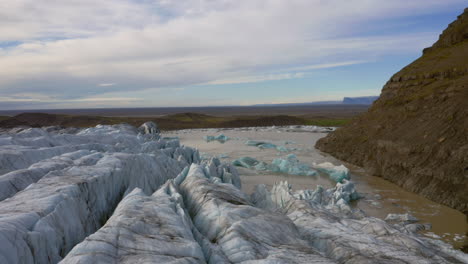 antena: toma panorámica lenta de icebergs derritiéndose en la laguna glaciar