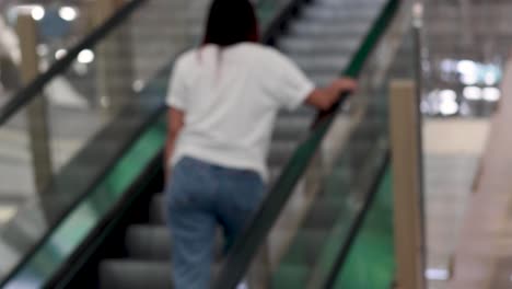 individual riding up an escalator in a building