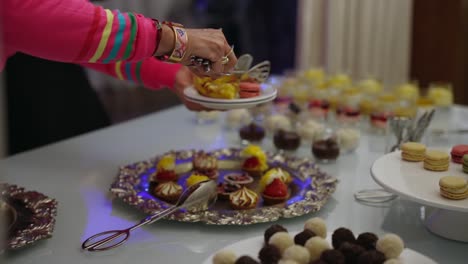 hand selecting desserts from elegant dessert table