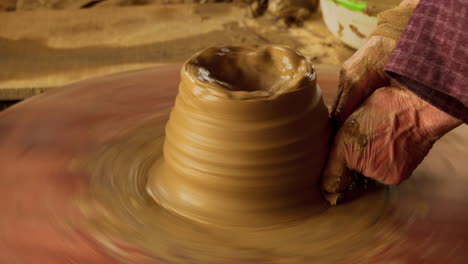 Close-up-of-the-process-of-making-new-clay-pottery-in-Thanh-Ha,-capturing-the-beginning-stages-of-turning-pottery-on-a-food-powered-table,-showcasing-traditional-craftsmanship-and-artistry