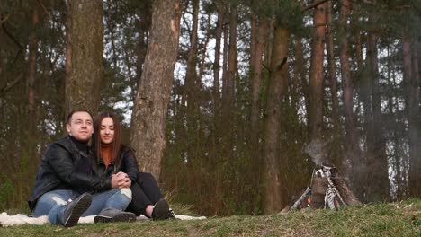 couple enjoying a campfire in the forest