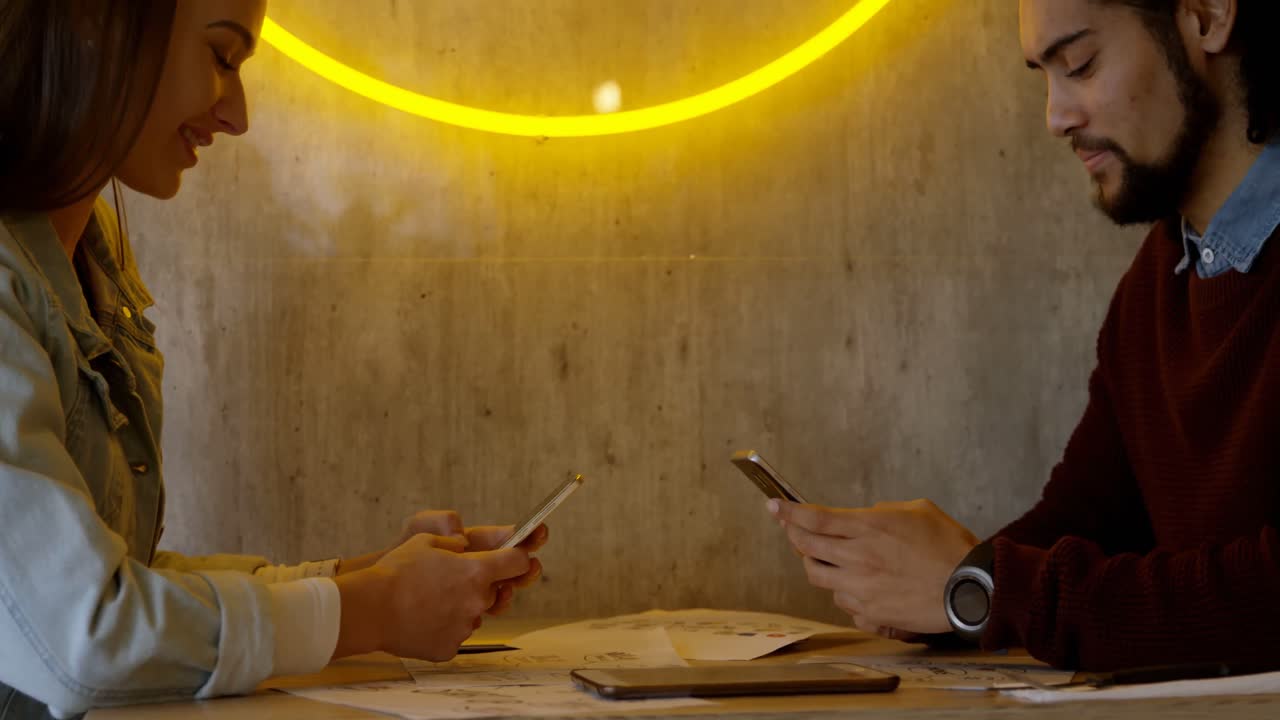 pareja usando teléfono móvil en la cafetería 4k