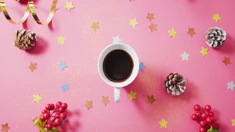 video of coffee, red berries, stars and pine cones on pink background