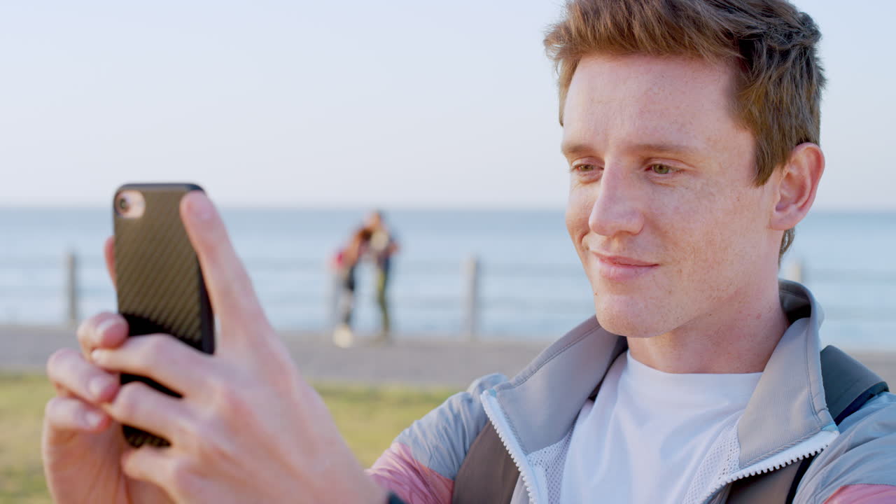 selfie telefónico, videollamada y hombre en la playa