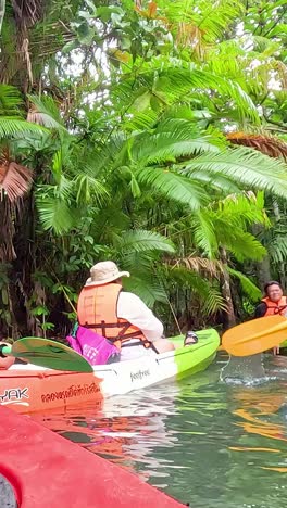 group kayaking through lush, tropical canal