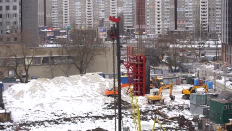 vista aérea superior del sitio de construcción de la ciudad. grúas torre para la construcción de nuevos apartamentos bajo la nieve en invierno