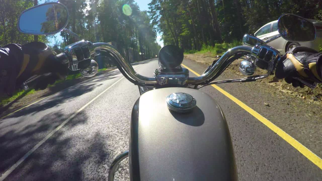 오토바이를 타고. 오토바이를 타는 사람은 첫 번째 사람과 함께 도로를 타고 있습니다.