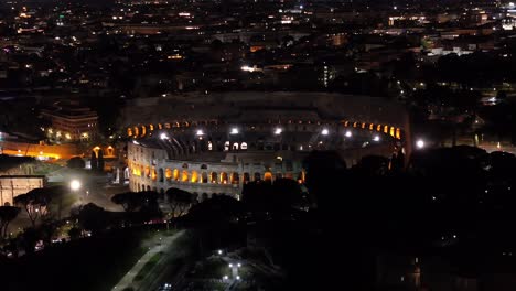 drone view of roman colosseum at night in rome, italy