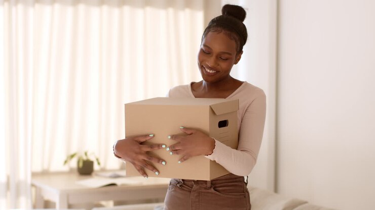 Woman Excitedly Holding a Cardboard Moving Box