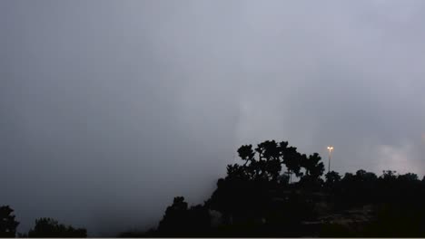 Lapso-De-Tiempo-De-La-Niebla-De-Las-Nubes-A-Lo-Largo-De-La-Torre-De-Señales-Y-La-Luz-De-La-Calle