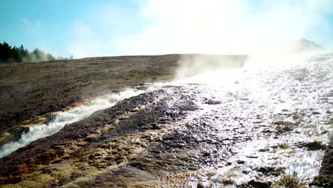 el agua caliente al vapor fluye hacia el río firehole en las aguas termales prismáticas en el parque nacional de yellowstone