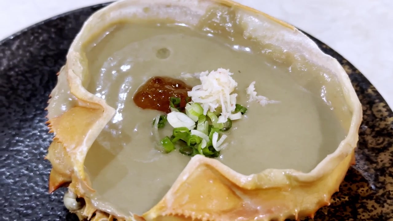 Close-up cangkang kepiting berisi tomalley kepiting yang kaya dan lembut, disajikan dengan indah sebagai hidangan laut premium dalam masakan Jepang.