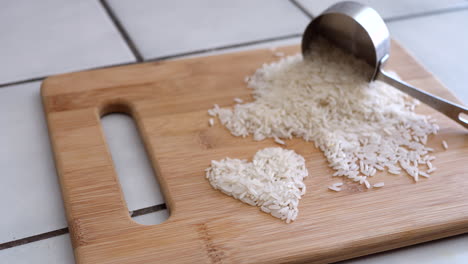 white rice grain in a heart with cooking utensils and measuring cup in a kitchen slide right