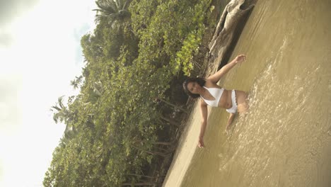 A-young-girl-in-the-water-with-a-scenic-background-while-the-camera-does-a-three-sixty-roll-on-a-gimbal