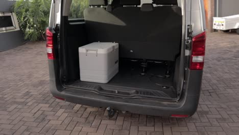 a tilt up shot of back side view of a van with open rear doors