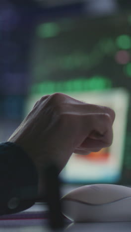 Female-financial-analyst-and-investment-manager-discuss-real-time-stocks-data-on-computer.-Colleagues-work-in-bank-office.-Big-digital-screens-showing-exchange-market-charts.-Vertical-shot